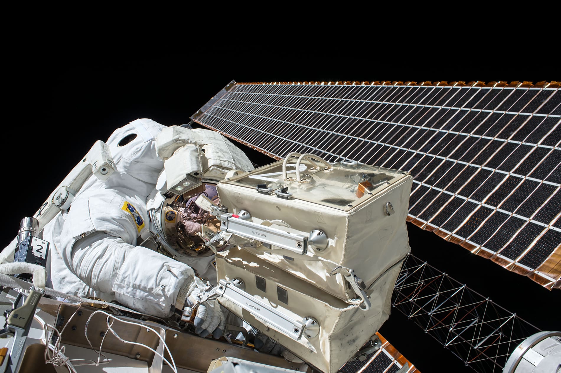 Astronaut working beside a solar array in orbit